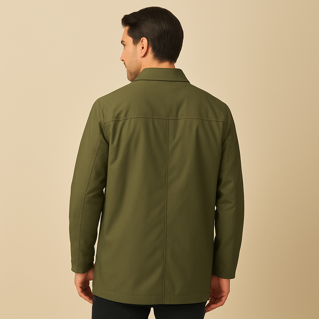 Men’s mid-length trench coat in matte fabric, worn by a male model against a plain beige background. The coat features a pointed collar, concealed button placket, side welt pockets, and a tailored silhouette, styled for a clean, classic look.