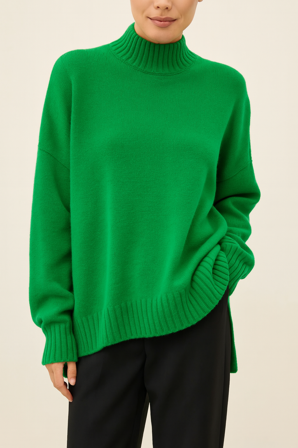 Nordash Oversized Turtleneck Sweater in emerald green, soft knit texture with shorter ribbed collar, styled with black trousers in studio lighting.