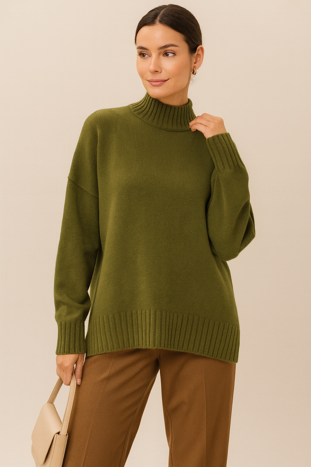 Model wearing Nordash Oversized Turtleneck Sweater in olive green, premium ribbed knit, paired with camel tailored trousers against neutral backdrop.